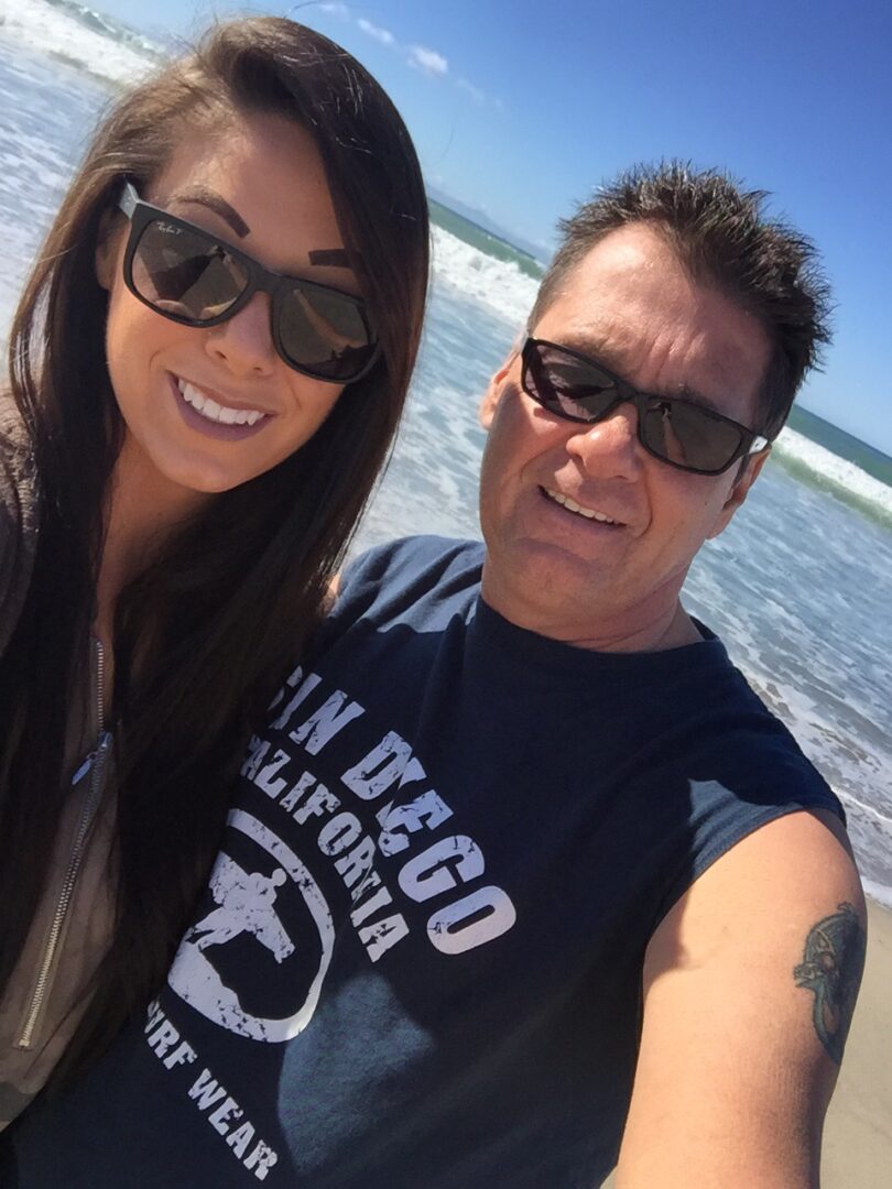 A man and woman standing on the beach.