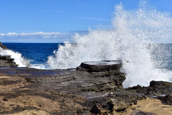A wave crashing on the rocks of an ocean beach.