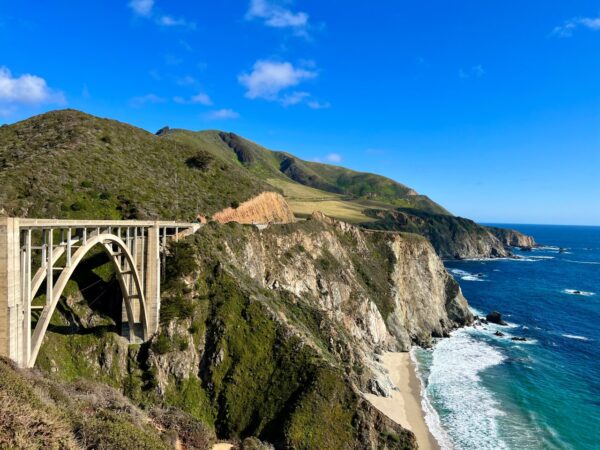 A bridge over the ocean near a cliff.