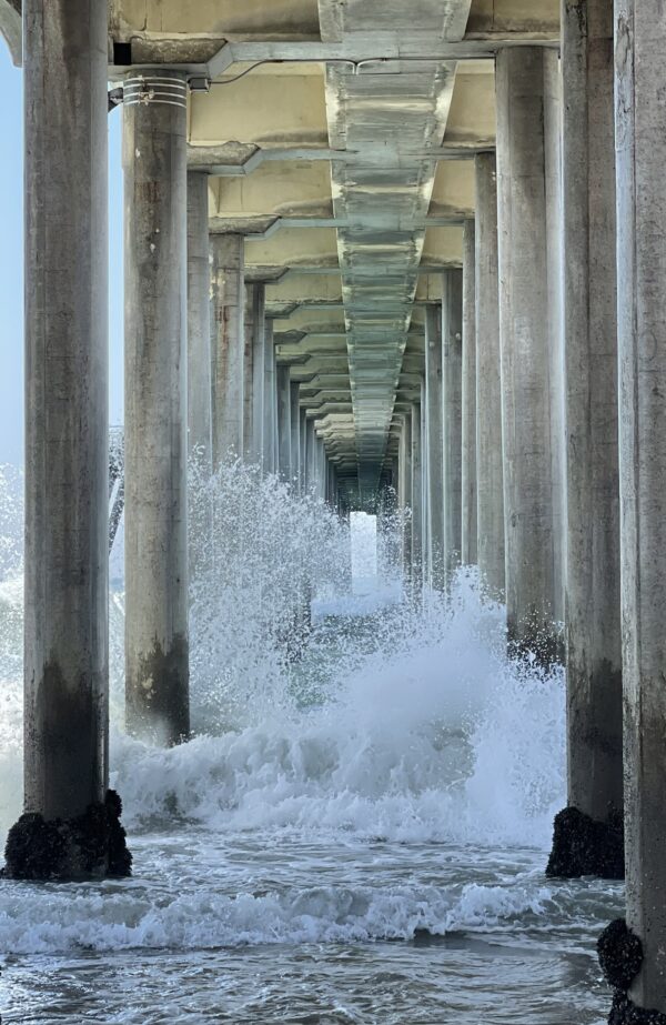 A pier with waves crashing on it's side.