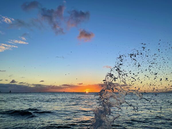 A sunset over the ocean with a splash of water